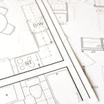 Close-up view of an architectural floor plan on paper showcasing detailed room layouts and measurements.